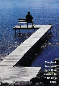 photo of a person sitting on a bench on a dock